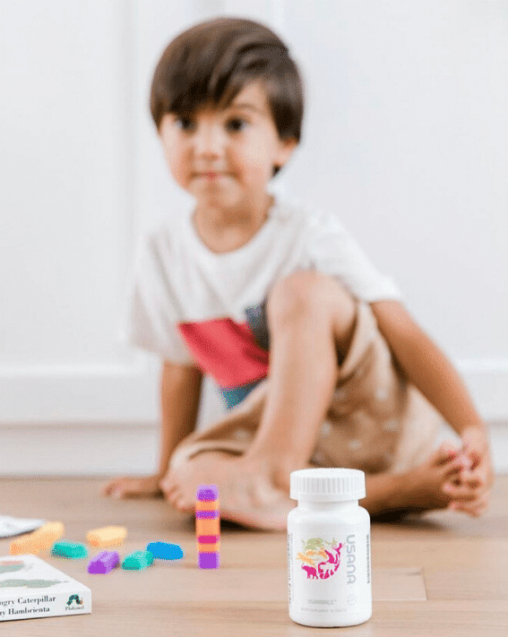 Usana Supplement review. Child sitting with Usana supplement bottle
