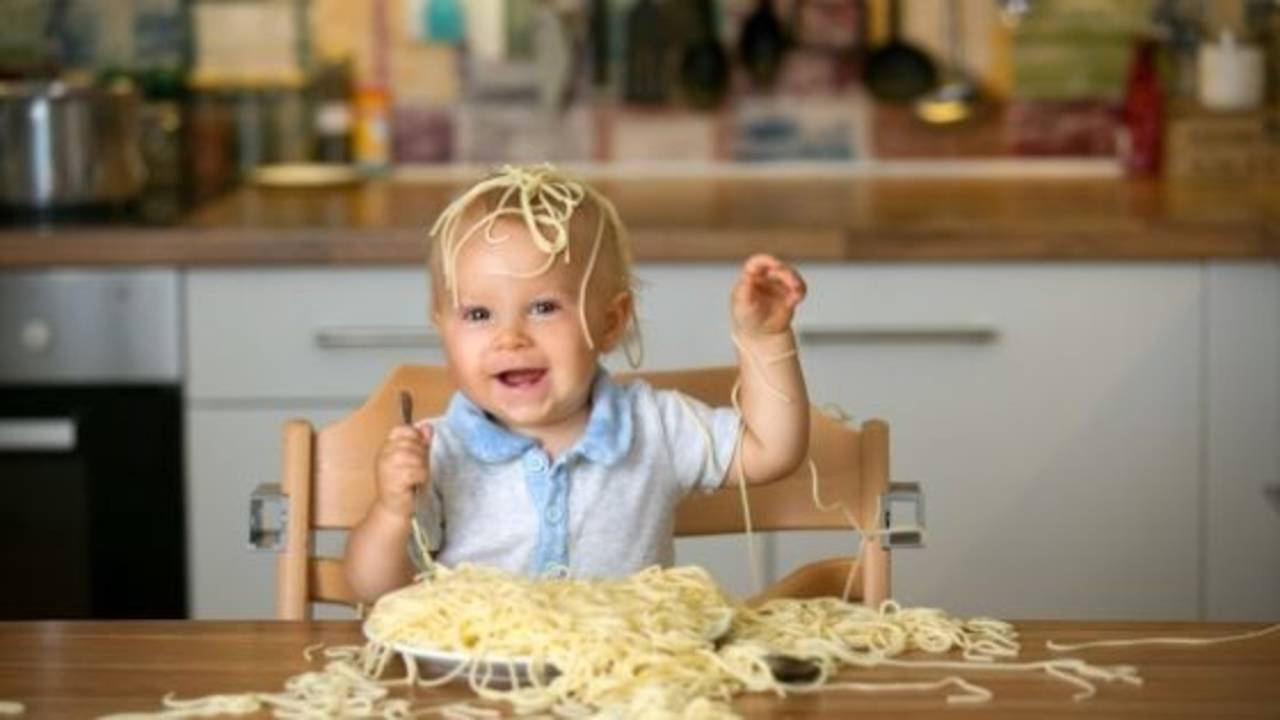 Baby eating a plate of spaghetti