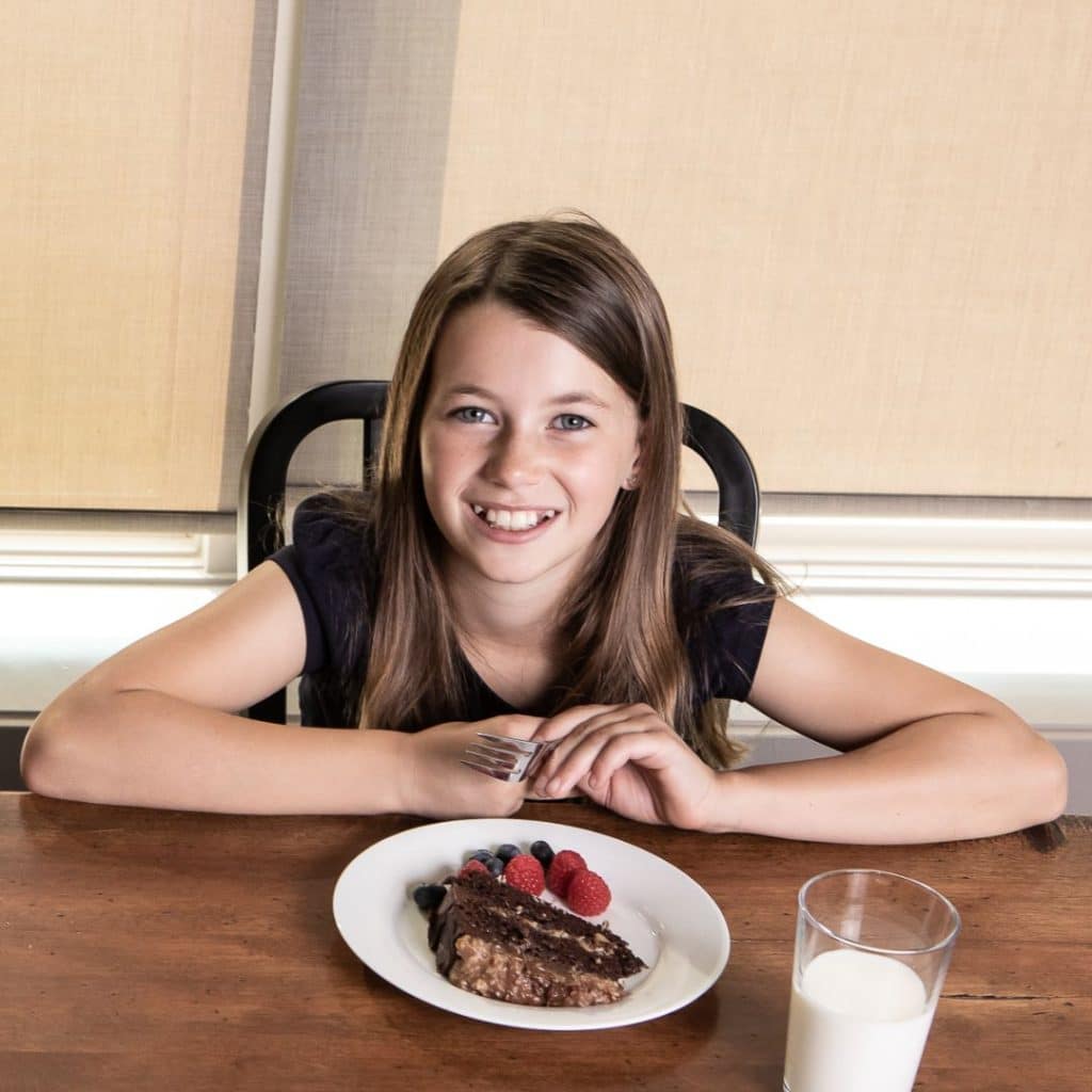 Older picky eater at the table with cake and berries