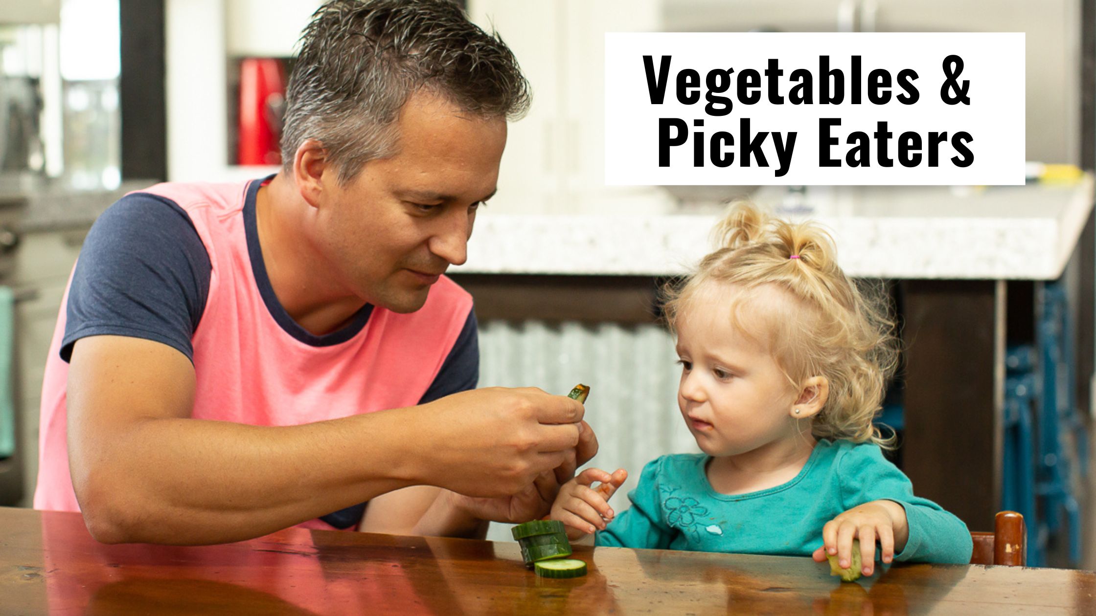 Picky eaters and vegetables- feeding a little girl a cucumber.